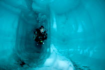 Scuba diver inside a cave ice, Lake Sassolo, Sambuco valley, Ticino, Switzerland