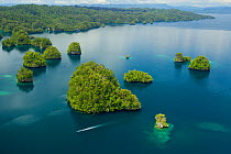 Limestone Islands of Kabui Bay, near the East end of the Passage between Gam and Waigeo. Waigeo Island at top. A local boat is heading for the Passage. Raja Ampat Islands, West Papua, Indonesia. Octob...