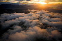 Aerial view of sunrise, low clouds and the Sarawaget Range - mountains of the Huon Peninsula, Papua New Guinea