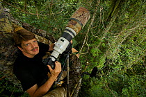 Photographer Tim Laman with camera set up on canopy platform to shoot King Bird of Paradise. Oransbari, Bird's Head Peninsula, New Guinea. August 2009