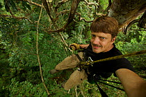 Photographer Tim Laman ready to rappel after shooting from his canopy platform. Oransbari, Bird's Head Peninsula, West Papua, New Guinea. August 2009