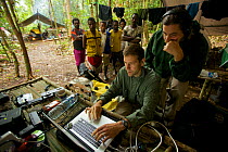 Eric Liner reviews footage on his laptop, while Edwin Scholes and villagers look on. West Papua, New Guinea, August 2009
