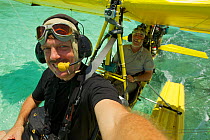 Photographer Tim Laman in the front seat with pilot Max Ammer in ultralight float plane before take off to shoot aerials of the Raja Ampat Islands, West Papua, Indonesia. October 2010