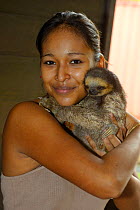 Girl holding young Pale-throated sloth / Aï (Bradypus tridactylus) French Guiana.