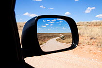 Wing mirror view of road through Kgalagadi Transfrontier Park, Northern Cape Province, Road, South Africa, February 2013 (This image may be licensed either as rights managed or royalty free.)