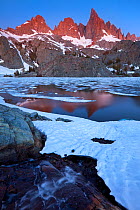 Early dawn light shines on the Minarets, which tower over the partially frozen Minaret Lake in the Ansel Adams Wilderness in Sierra Nevada. California. June 2009