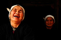 Two Dong women, one laughing, in a dark room, Sanjiang Dong Village in the province of Guangxi, China. April 2009. Winner of the Photographer of the Year, Portrait Category, 4th Pollux Awards, 2012