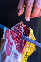 Thin slice being cut off Iberico ham / Jamon Iberico, Caceres, Ambroz Valley, Extremadura, Spain.