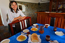 Bed and breakfast hotel owner Betty, standing by dinner table, Wild Farm in Madzharovo valley, Eastern Rhodope Mountains, Bulgaria, May 2013.
