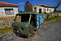 Abandoned houses and cars in street, Studen Kladenets, Eastern Rhodope Mountains, Bulgaria, May 2013.