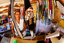 Woman in a shop selling a sword with a Clouded leopard (Neofelis nebulosa) jaw as an adornment, Arunachal Pradesh, India.