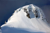 Snowboarders below Table Mountain in the Mount Baker Wilderness, Washington, USA. March 2013.
