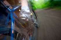 Close up on mountain biker's foot pedalling, in Cascade foothills, Washington, USA. April 2013.