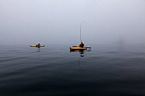 Men kayak fishing on a foggy morning in the Strait of Juan de Fuca, Washington, USA, August 2013. Model released.