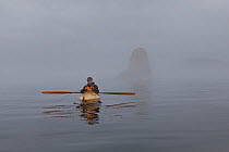 Man kayak fishing on a foggy morning in the Strait of Juan de Fuca, Washington, USA, August 2013.