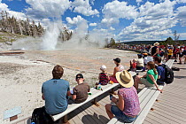 Crowd observing the Turban and Giant Geysers in the Upper Geyser Basin of Yellowstone National Park, Wyoming, USA, June 2013.