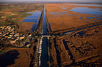 Gallician village and canal through marshland, Gallician marshes, Camargue, France.