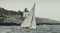 6 metre yacht passing Castle Hill Lighthouse, which marks the entrance to Narragansett Bay, during the Classic Yacht Regatta, Newport, Rhode Island, USA, August 2013. All non-editorial uses must be cl...
