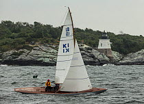 15 square metre yacht passing Castle Hill lighthouse, during the Classic Yacht Regatta, Newport, Rhode Island, USA, August 2013. All non-editorial uses must be cleared individually.