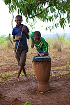 Boys playing snooker with marbles using a homemade table and cues, Miono Region, Tanzania