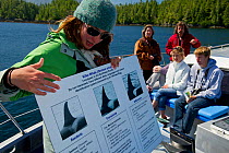 Whale watching guide gives a lecture to whale watching tourists on board about Humpback whales, Orcas and other marine mammals and the negative effects of marine pollution on these animals. Johnstone...