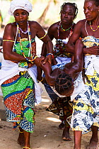 Mami Wata women carrying woman in trance during a Voodoo / Vodun ceremony, Benin, February 2011.