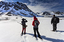 Tourists with a guide on an ecotourism trekking holiday, Svalbard, Norway, June, 2012. Model released.