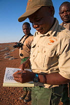 Save the Rhino Trust trackers Denso Tjiraso,  Martin Nawaseb foreground and Epson Rukama at Desert Rhino Camp, Wilderness Safaris, Kunene region, Namibia, May 2013