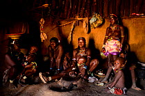 Ovahakaona women and children in hut at grinding stone, Kaokoland, Namibia, September 2013.