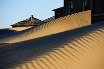 Kolmanskop Ghost Town, an old diamond-mining town where shifting sand dunes have encroached abandoned houses, Namib Desert Namibia, September 2013.