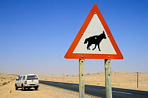 Traffic sign warning of Brown hyaenas (Hyaena brunnea) on a coastal road, Luderitz, Namib desert, Namibia.