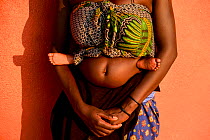 Ovahakaona woman with her child on her back wrapped in a scarf. Opuwo, Kaokoland, Namibia, September 2013.