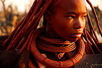 Portrait of Himba woman with characteristic Otjize (a mix of butter ash and ochre) covering hair and skin, Kaokoland, Namibia, February 2005