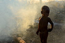 Himba child in smoke from fire. Kaokoland, Namibia, September 2013.