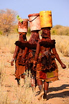 Himba women carrying goods on their heads. Kaokoland, Namibia, September 2013.