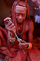 Himba woman snorting nasal snuff tobacco. Kaokoland, Namibia, September 2013.