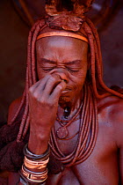Himba woman snorting snuff tobacco. Kaokoland, Namibia, September 2013.