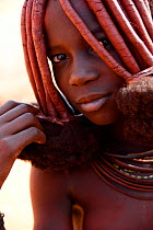 Portrait of Himba woman with characteristic Otjize (a mix of butter ash and ochre) covering hair and skin, Kaokoland, Namibia.