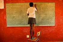 Girl writing on blackboard in rural school in the region of Kaokoland, Namibia, February 2005.