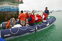 Passengers being ferried to dive excursion vessel at the marina in San Cristobal, Galapagos Islands, September 2011. Property released and model released.