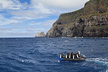 Scuba divers traveling to dive site aboard inflatable boat,, Galapagos Islands, September 2011. Property and model released.