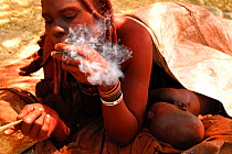 Himba woman smoking snuff, Namibia, February 2005.