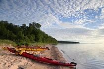Kayaks on a beach at the edge of Lake Superior, Apostle Islands National Lakeshore, Bayfield peninsula, Wisconsin, USA, July.