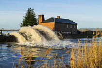 River Parrett in foreground with massive jets of water from emergency pumps taking water off surrounding flooded fields. Near the village of Burrowbridge, Somerset, UK. January 2014.