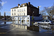 View of floodwater outside the Severn View Hotel, with a car creating a bow wave as it passes through, Worcester, England, UK, February 2014.