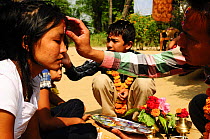 Woman having paste applied to her forehead during the celebration of Diwali / Tihar (the festival of lights) taken in a small village around the Royal Chitwan National Park, Nepal, October 2011.