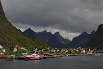 Looking across the harbour with boats and mountains, Norway Sea, Moskenesoya, Lofoten Islands, Norway, June.