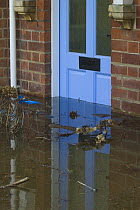 Flooding outside house with debris in front of door during February 2014 floods, Upton upon Severn, Worcestershire, England, UK, 9th February 2014.