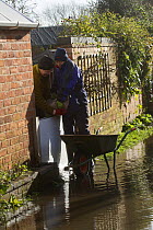 Couple installing sand bags to prevent flooding to their home during February 2014 floods, Upton Upon Severn, Worcestershire, England, UK, 8th February 2014.