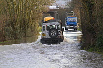 Landrover with kayak driving through water during the February 2014 floods, Gloucestershire, England, UK, 7th February 2014.